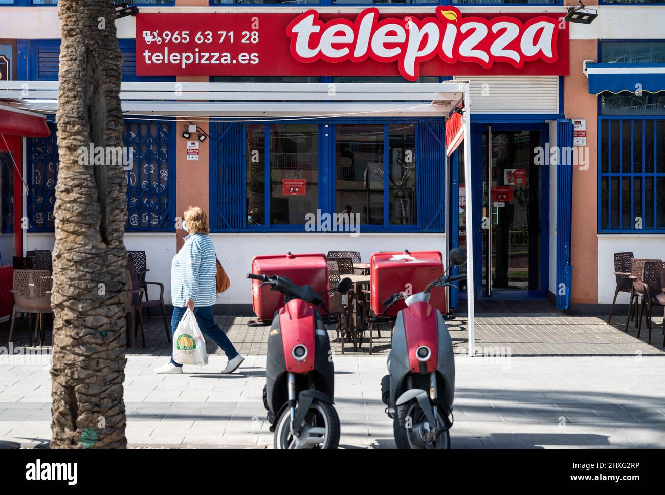 A pedestrian walks past the Spanish fast-food restaurant chain of Telepizza in Spain. Stock Photo