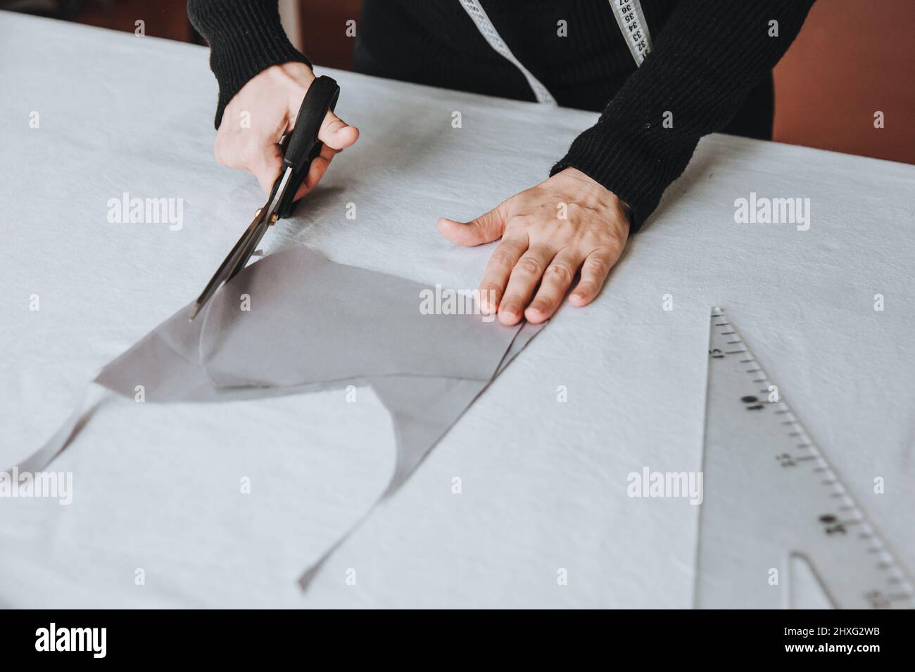 Tailor designer working of cutting piece of cloth with scissors, entrepreneur concept. Stock Photo