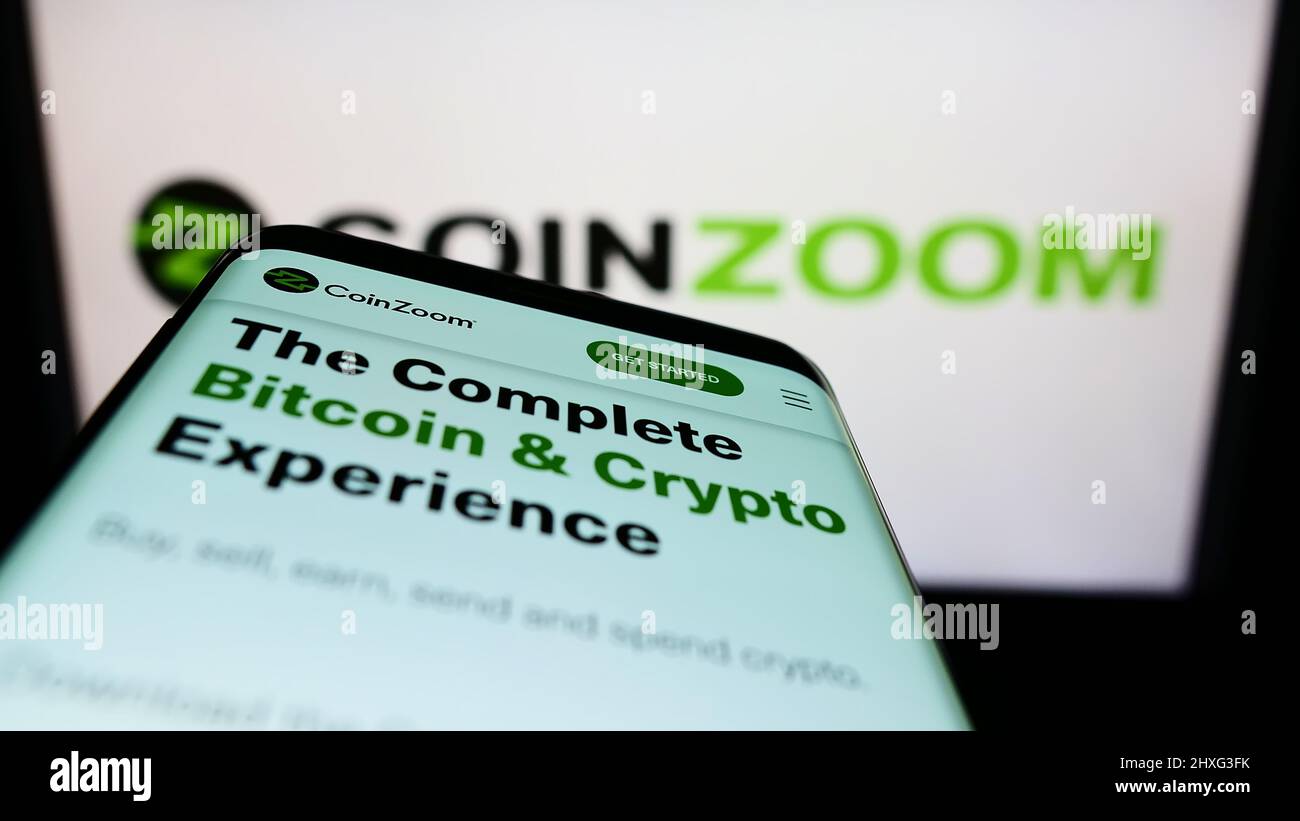 Mobile phone with website of American crypto exchange company CoinZoom Inc.  on screen in front of logo. Focus on top-left of phone display Stock Photo  - Alamy