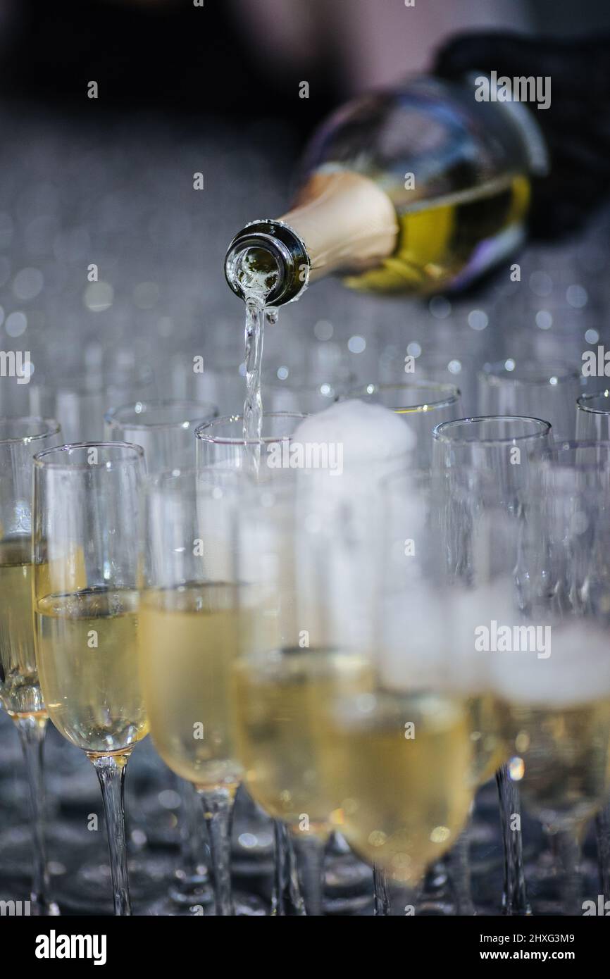 Champagne pouring in glasses from a bottle. Splash and drops. Concept for holidays. Stock Photo