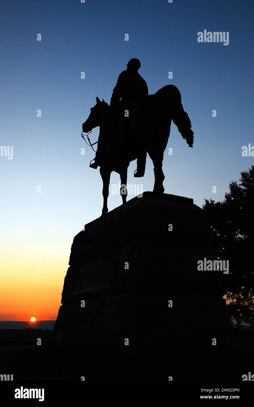 A memorial to General Meade stands in silhouette at sunset on the Gettysburg National Battlefield Stock Photo
