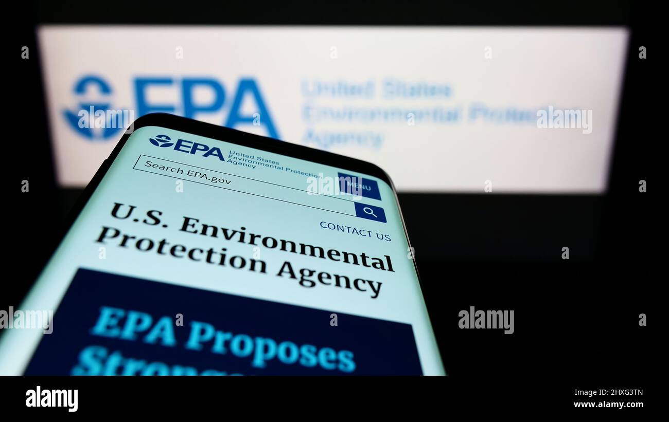 Mobile phone with website of US Environmental Protection Agency (EPA) on screen in front of logo. Focus on top-left of phone display. Stock Photo