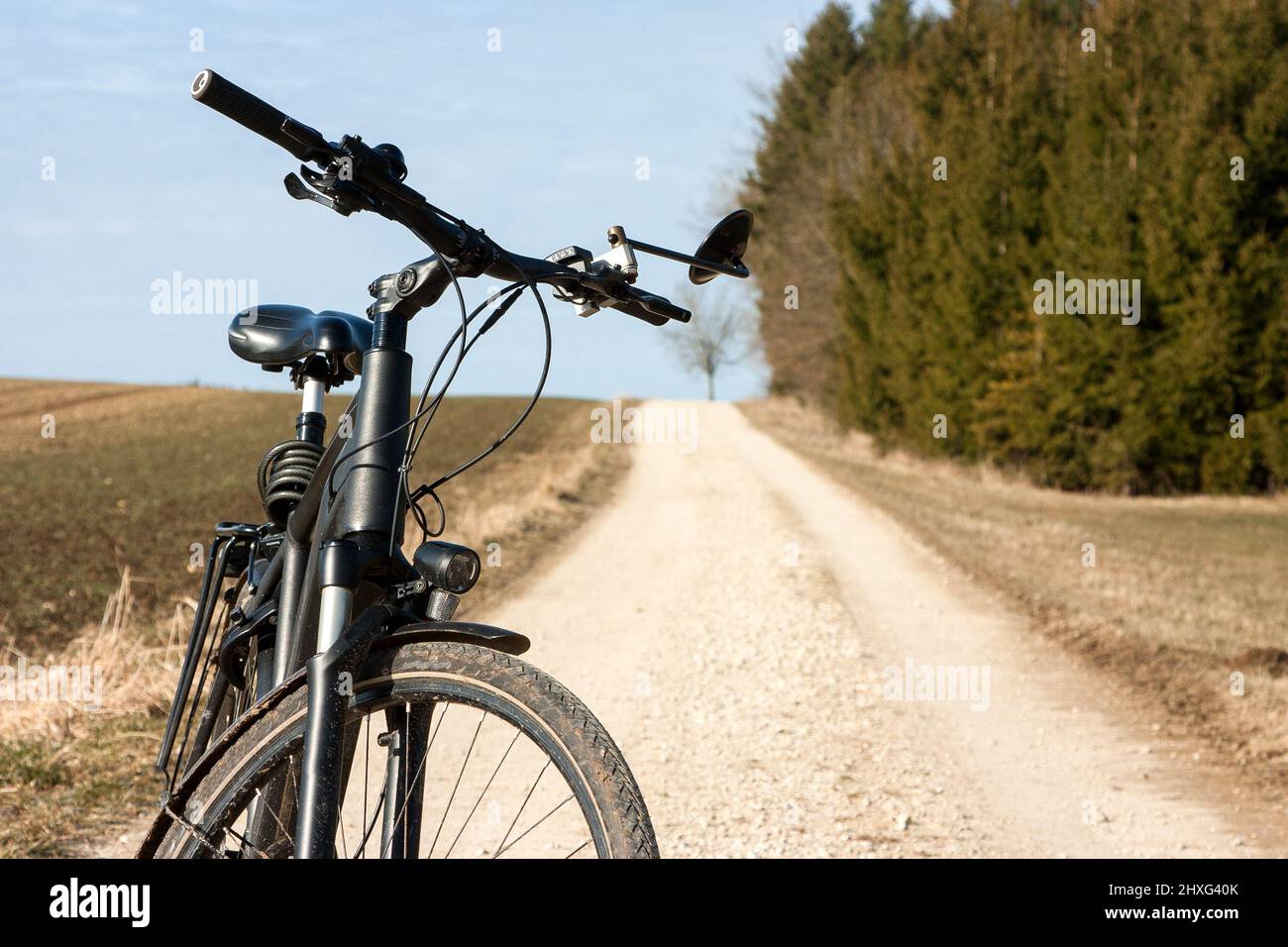 On the way with the trekking bike on remote country lanes through the spring-like nature. Stock Photo