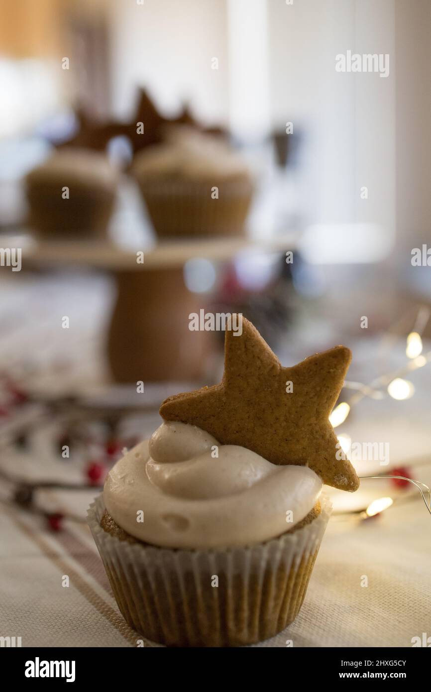 Cupcake with star cookie decorantion, twinkle lights, white tablecloth Stock Photo