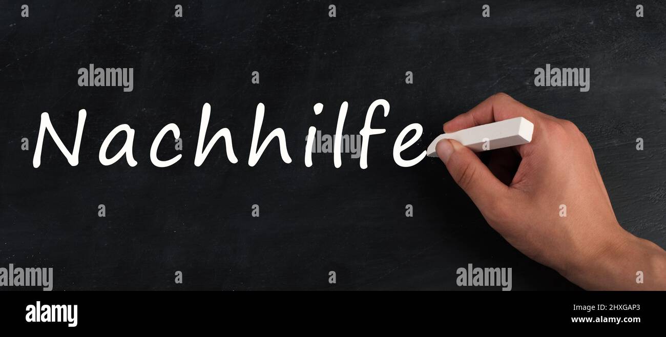 The word for private tutoring is standing in german language on a chalkboard, help for students, education concept Stock Photo