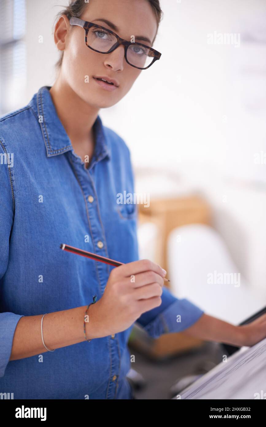 Paying attention to detail. Shot of an attractive architect working on blueprints. Stock Photo