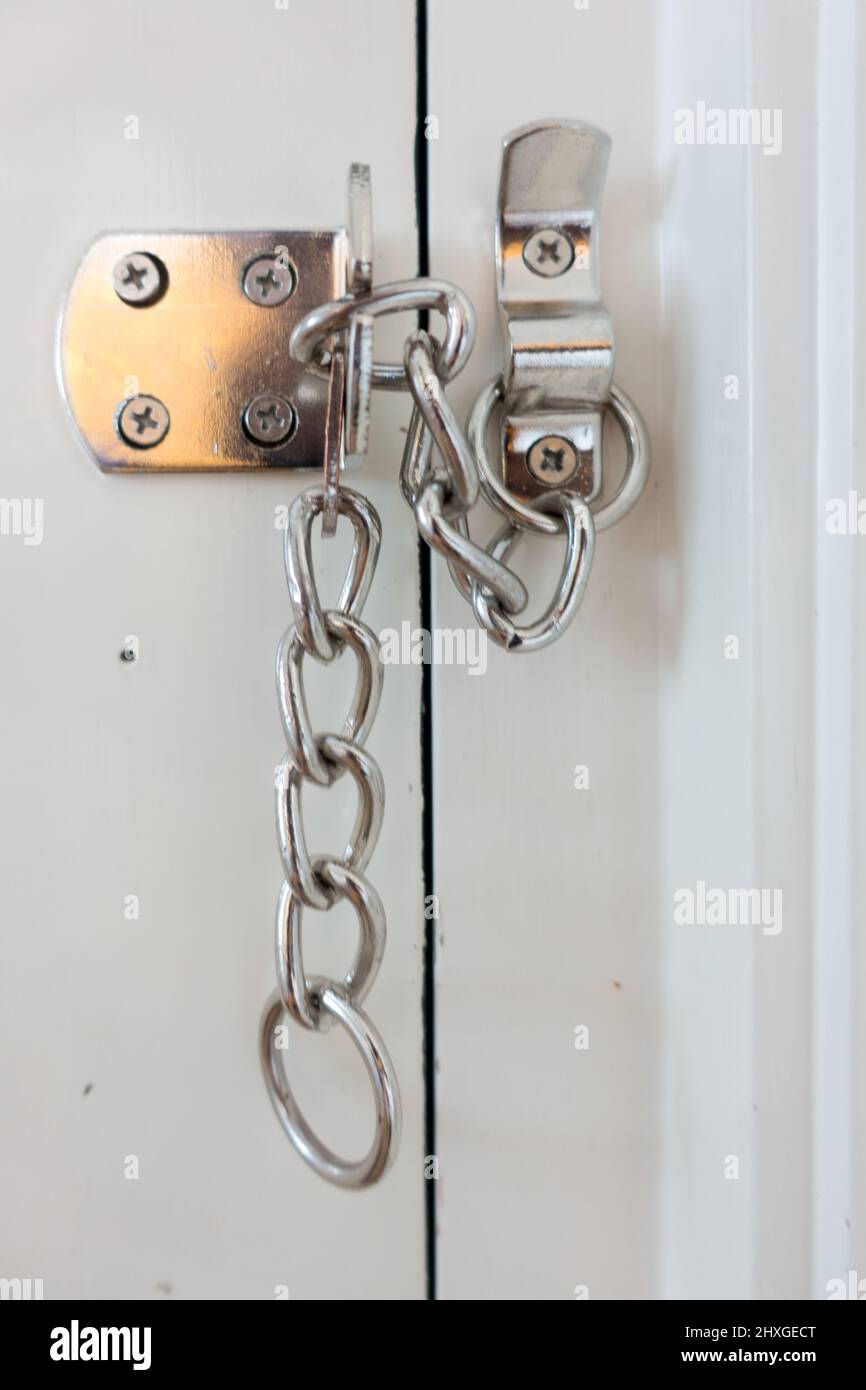 Door chain lock as added home security for Crime prevention Stock Photo