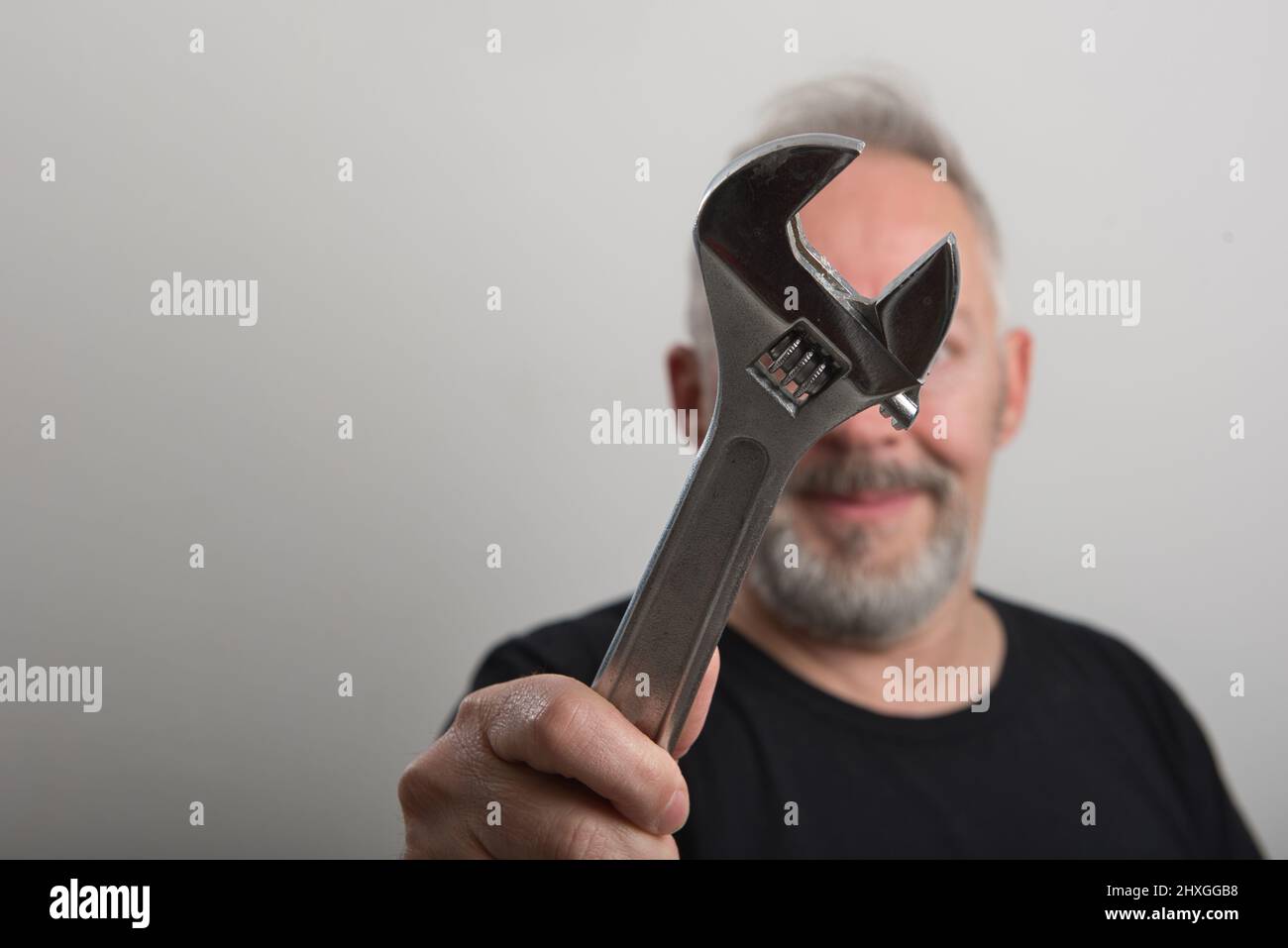 middle age worker with wrench in his hand Stock Photo