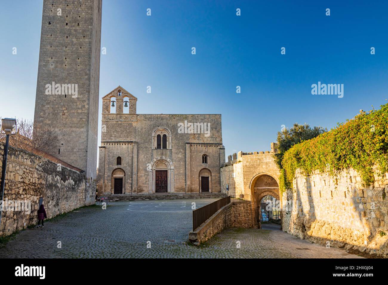 The village of Tarquinia, Viterbo, Lazio, Italy - The tower and facade of the Church of Santa Maria in Castello, in Romanesque style. Three arched doo Stock Photo