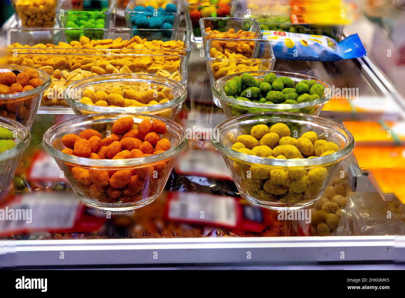 Nuts in spices, turmeric, paprika, pepper, salt and others are in the shop window Stock Photo