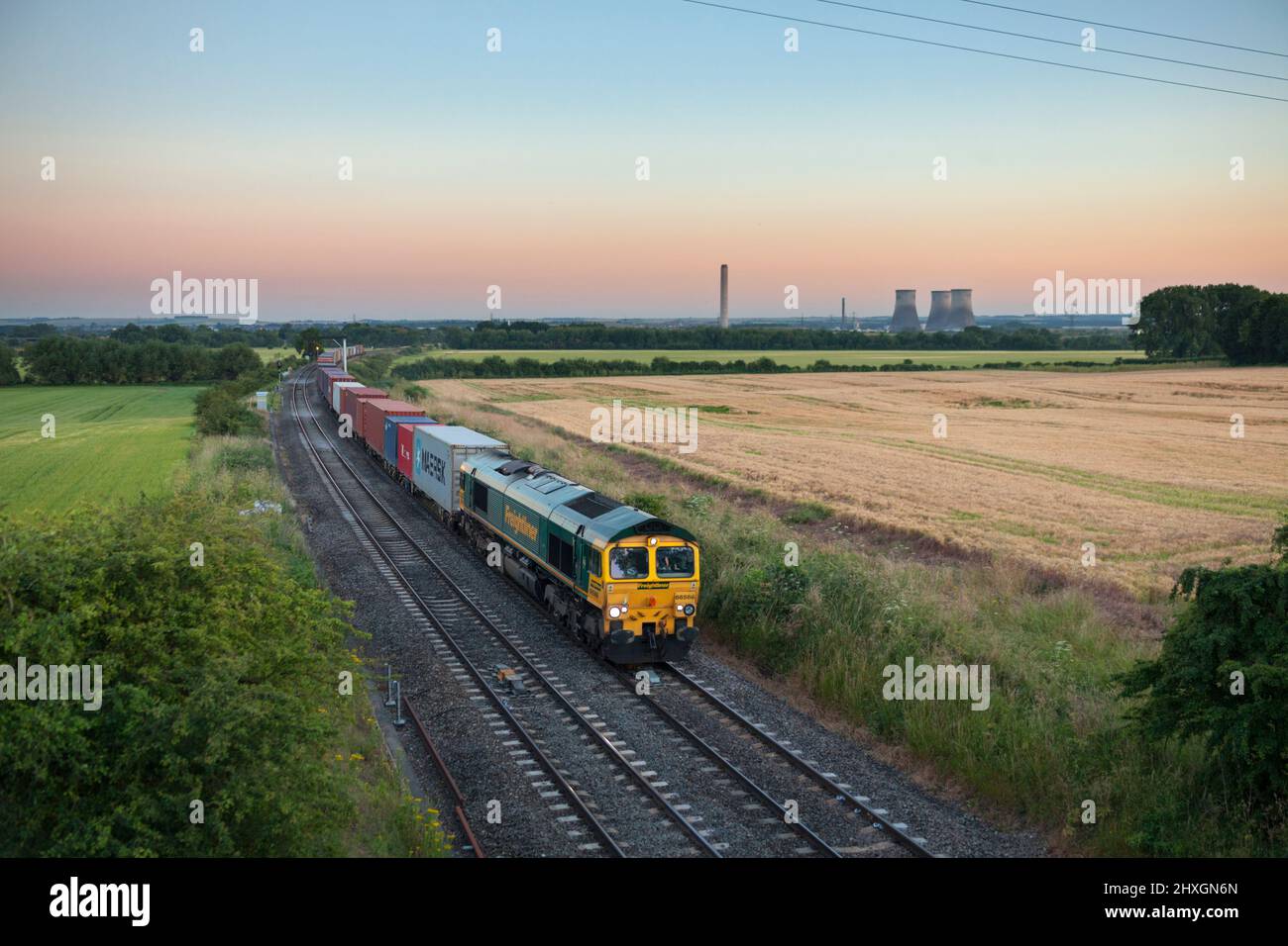 Freightliner class 66 diesel locomotive 66566 hauling a train of deep sea shipping containers passing Culham (north of Didcot) Stock Photo