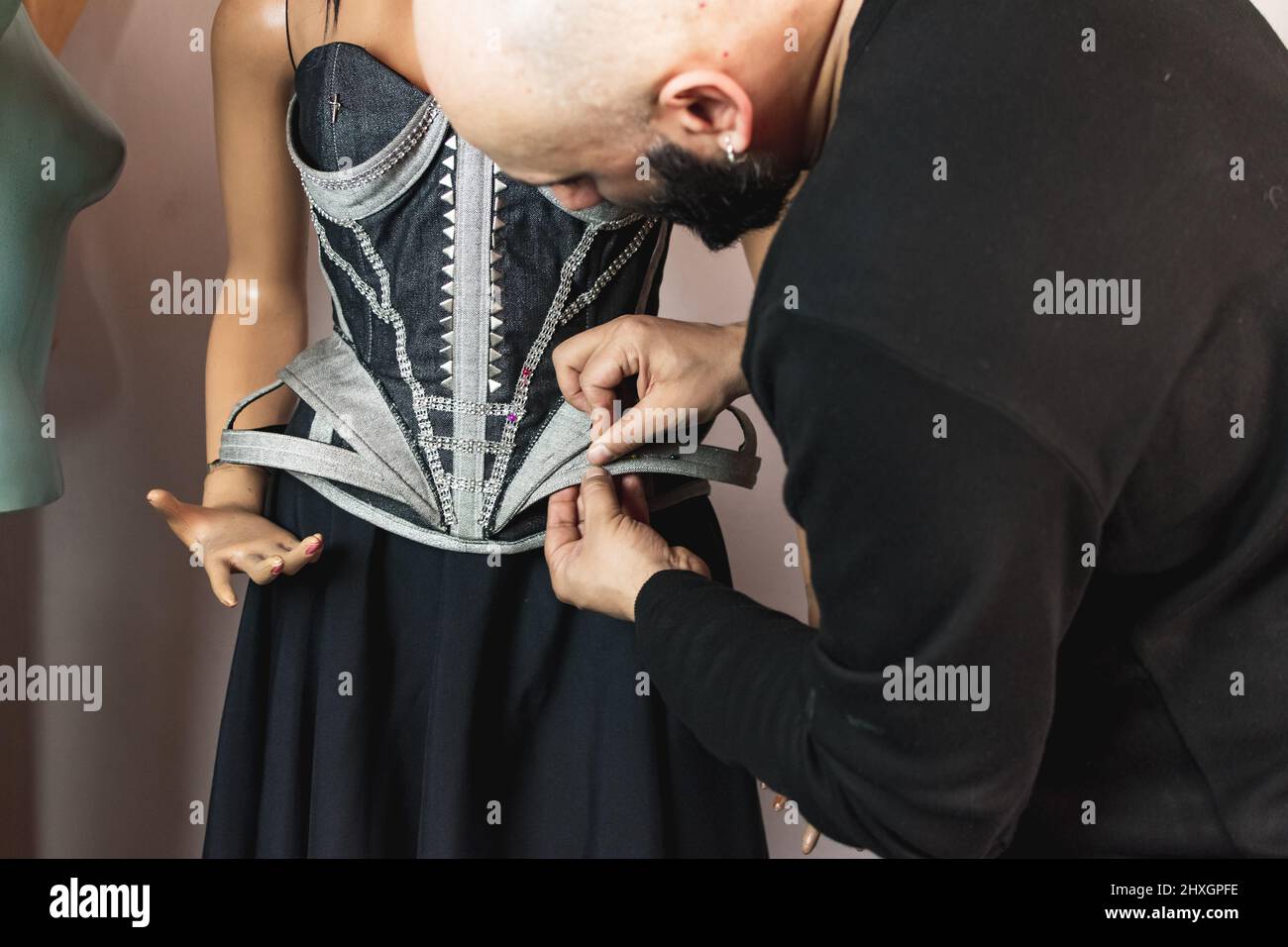 Close up photo of fashion designer working on his new creation. Using
