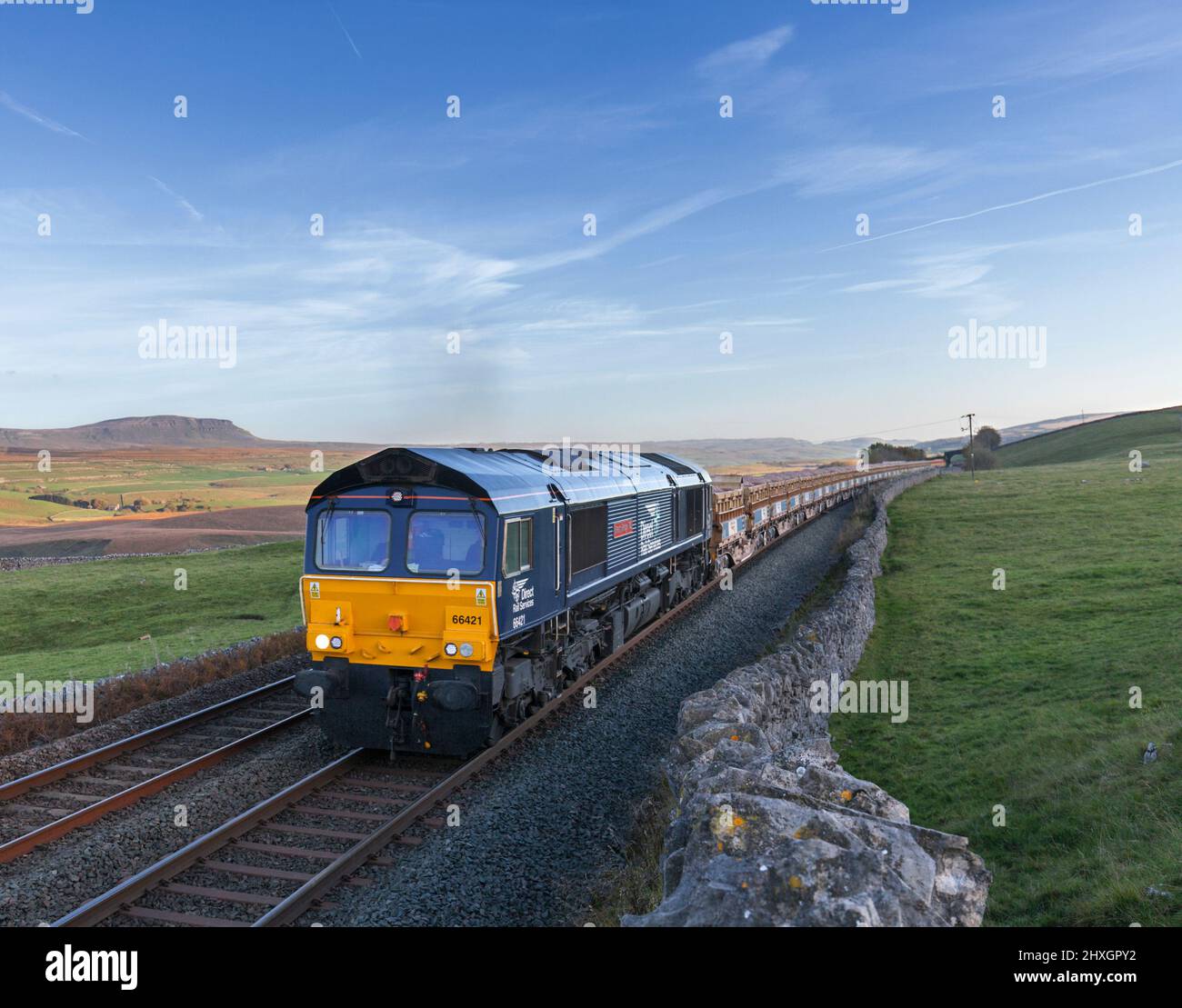 Direct rail Services class 66 locomotive at Ribblehead on the Settle  to Carlisle line with a freight train carrying railway ballast for Network Rail Stock Photo