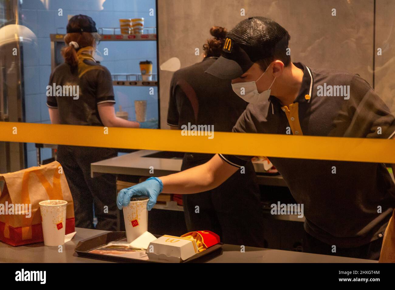 Moscow, Russia. 12th of March, 2022 An employee of the McDonald's restaurant chain is preparing an order for delivery in the restaurant on Tverskaya street in central Moscow, Russia. On March 8, 2022, the American fast food chain announced its plans to temporarily close its 850 Russian restaurants from March 14 Stock Photo