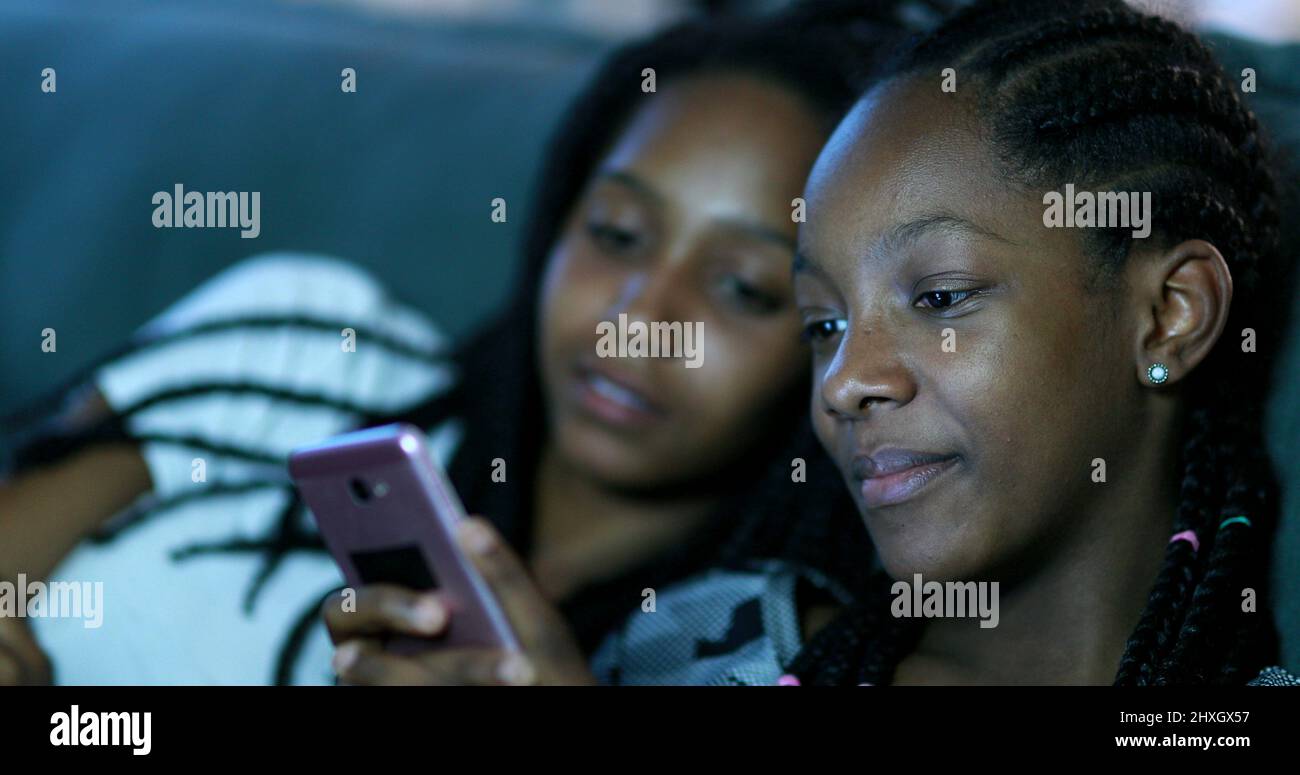 Candid black girls looking at cellphone screen. African American