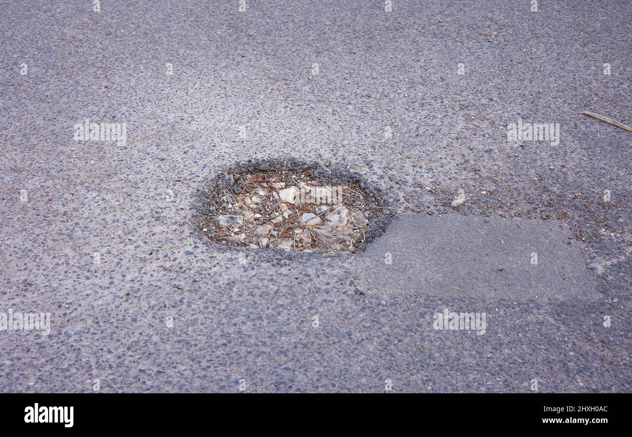 Round pothole seen in the tarmac of a road in the UK Stock Photo Alamy