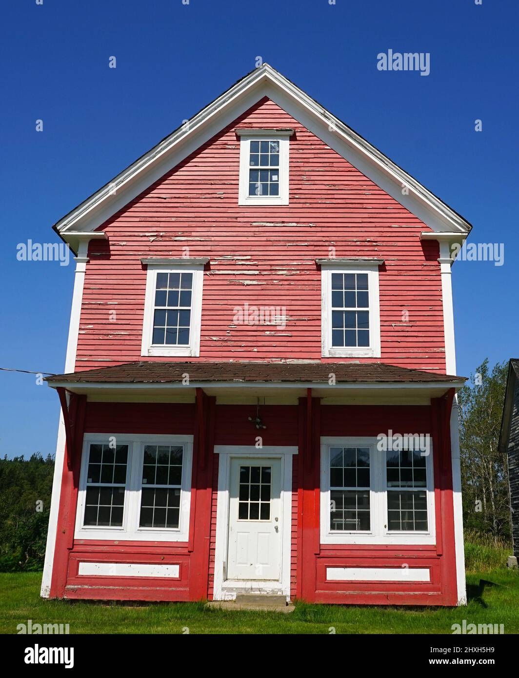 Brightly painted red and white clapboard house in the village of Shepody, in southern New Brunswick Stock Photo