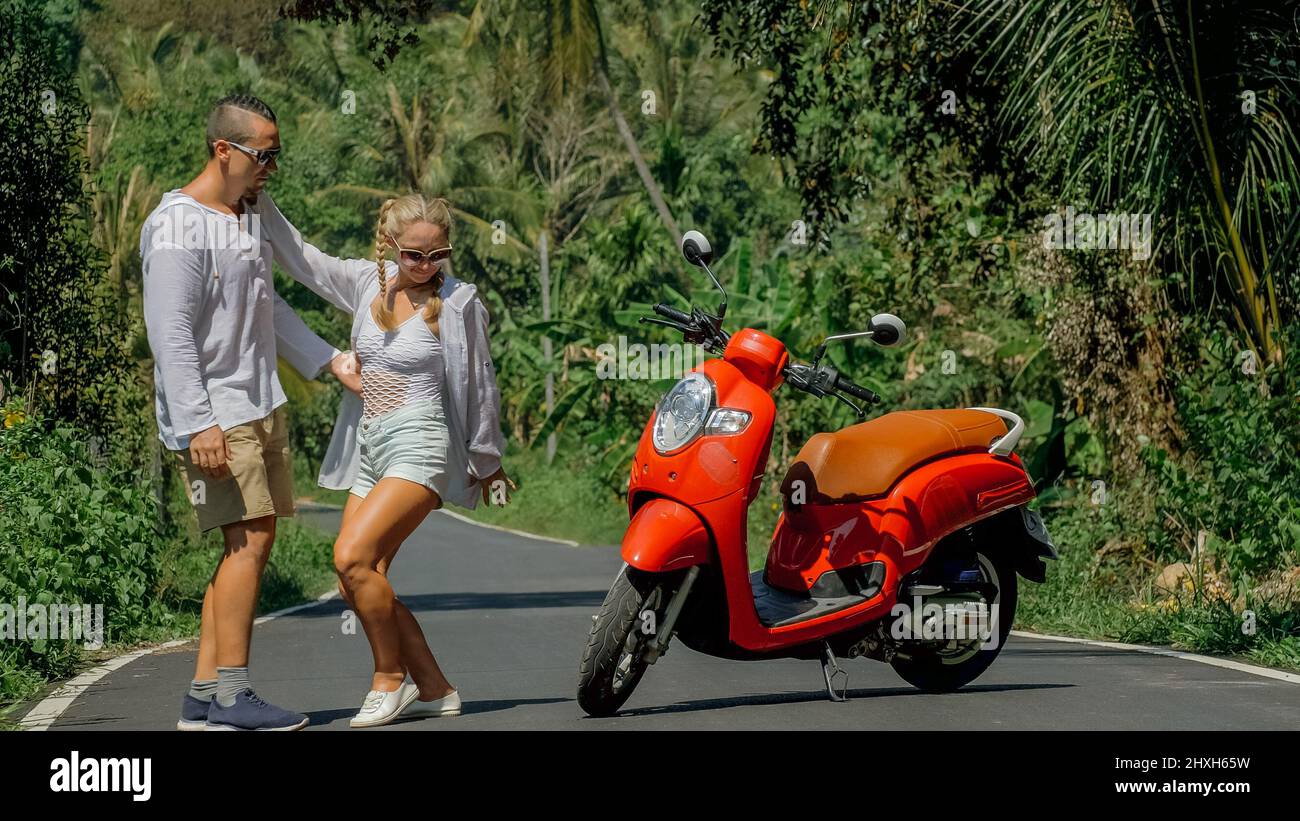 Happy smiling and screaming male tourist in helmet and sunglasses riding motorbike  scooter during his tropical vacation under palm trees Stock Photo - Alamy
