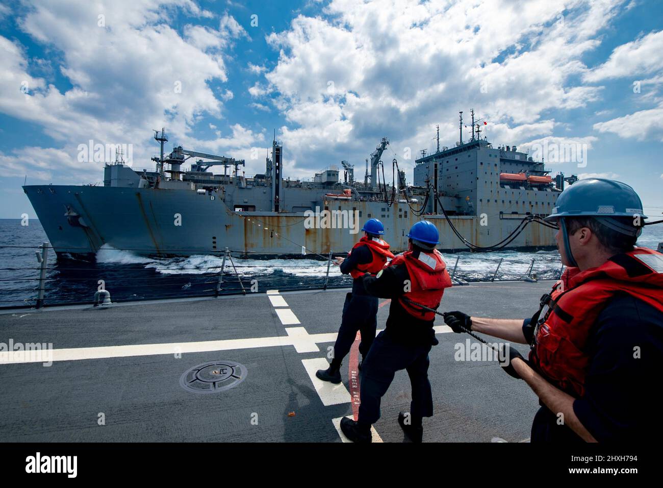 PHILIPPINE SEA (March 10, 2022) Sailors hold the phone and distance line during a replenishment-at-sea with the Military Sealift Command dry cargo and ammunition ship USNS Alan Shepard (T-AKE 3) aboard the Arleigh Burke-class guided-missile destroyer USS Spruance (DDG 111). Abraham Lincoln Strike Group is on a scheduled deployment in the U.S. 7th Fleet area of operations to enhance interoperability through alliances and partnerships while serving as a ready-response force in support of a free and open Indo-Pacific region. (U.S. Navy photo by Mass Communication Specialist 3rd Class Taylor Crens Stock Photo