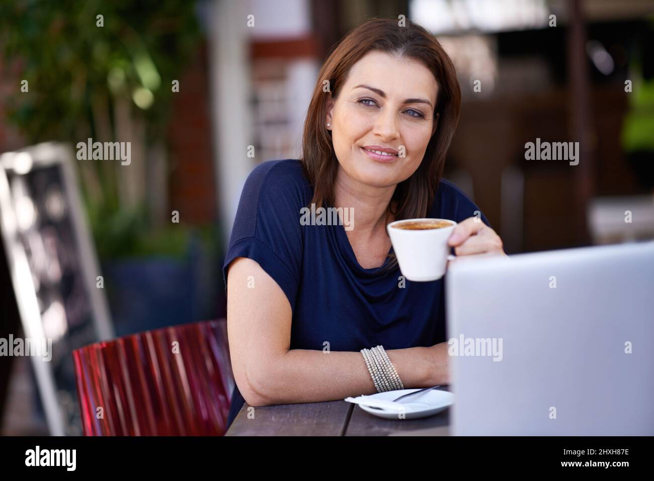 Blogging at the coffee shop. Shot of an attractive woman using her laptop at a coffee shop. Stock Photo