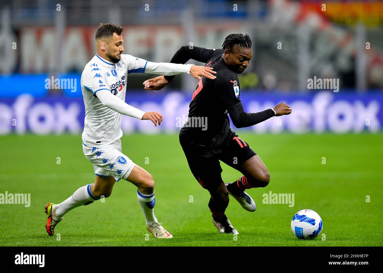 Milan, Italy. 12th Mar, 2022. AC Milan's Rafael Leao (R) vies with Empoli's Nedim Bajrami during a Serie A football match between AC Milan and Empoli in Milan, Italy, on March 12, 2022. Credit: Alberto Lingria/Xinhua/Alamy Live News Stock Photo