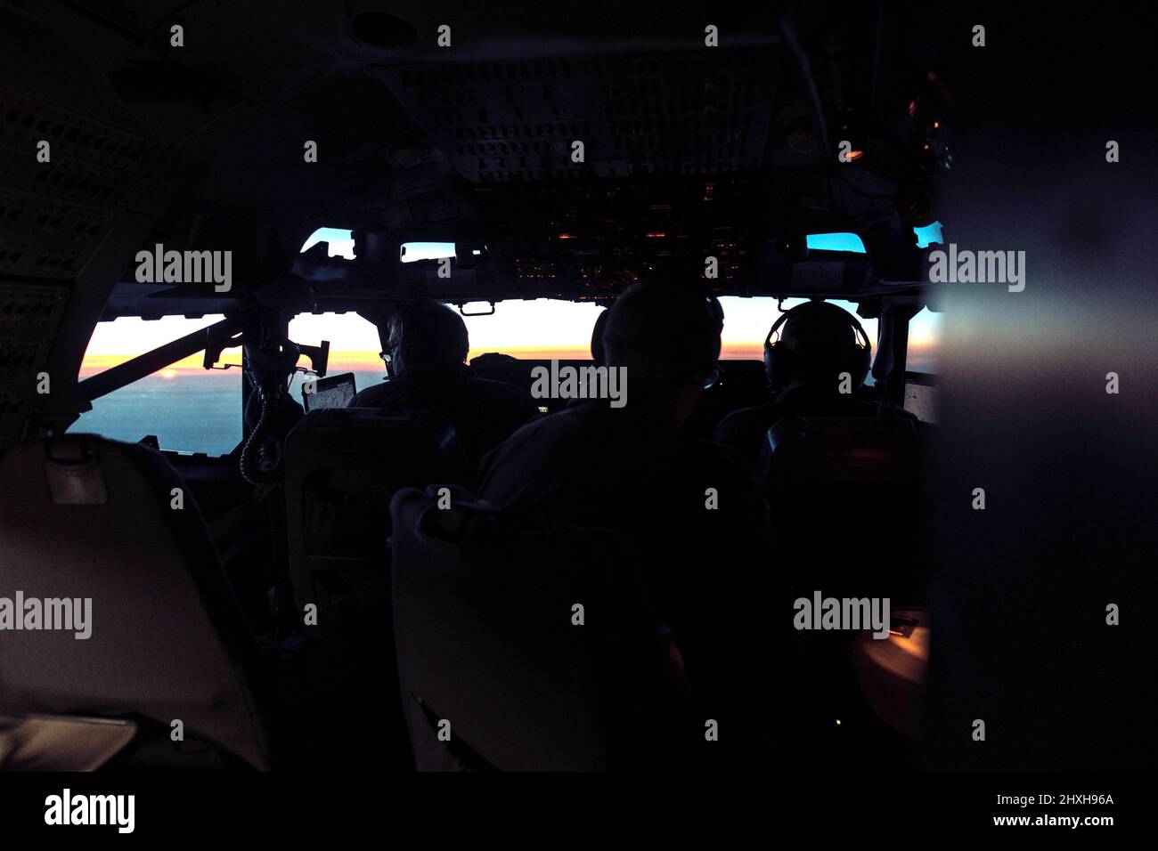 A cockpit sunset view from a NATO Boeing 707 E-3A AWACS. These aircraft are patrolling Allied airspace in Eastern Europe, in the wake of Russia’s attack on Ukraine. NATO’s Boeing E-3A Airborne Warning & Control System aircraft has a distinctive radar dome mounted on the fuselage which allows the crew to survey an area of more than 310,798 square kilometres, or about the size of Poland. (NATO Photo) Stock Photo