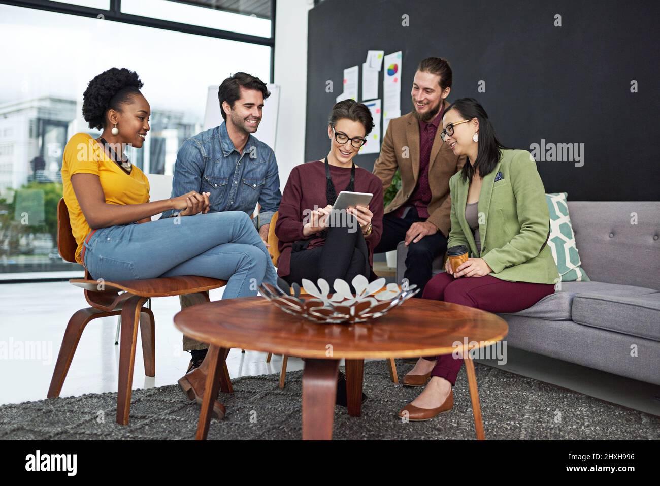 Working hard and dreaming big. Shot of a group of creative businesspeople looking at something on a tablet. Stock Photo