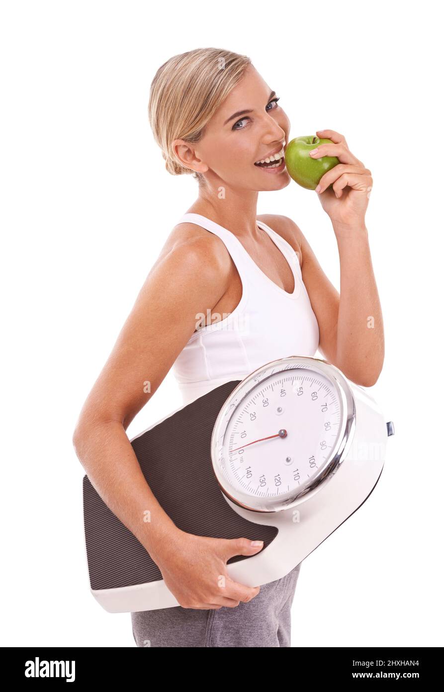 https://c8.alamy.com/comp/2HXHAN4/staying-slim-through-healthy-diet-studio-portrait-of-a-young-woman-eating-an-apple-and-carrying-a-scale-2HXHAN4.jpg