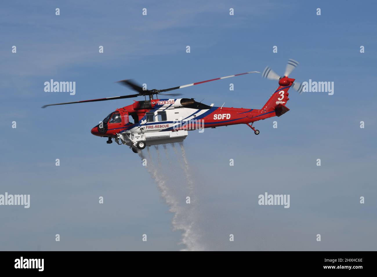 San Diego Fire-Rescue Copter 3 makes a water drop over Montgomery Field in San Diego, California Stock Photo