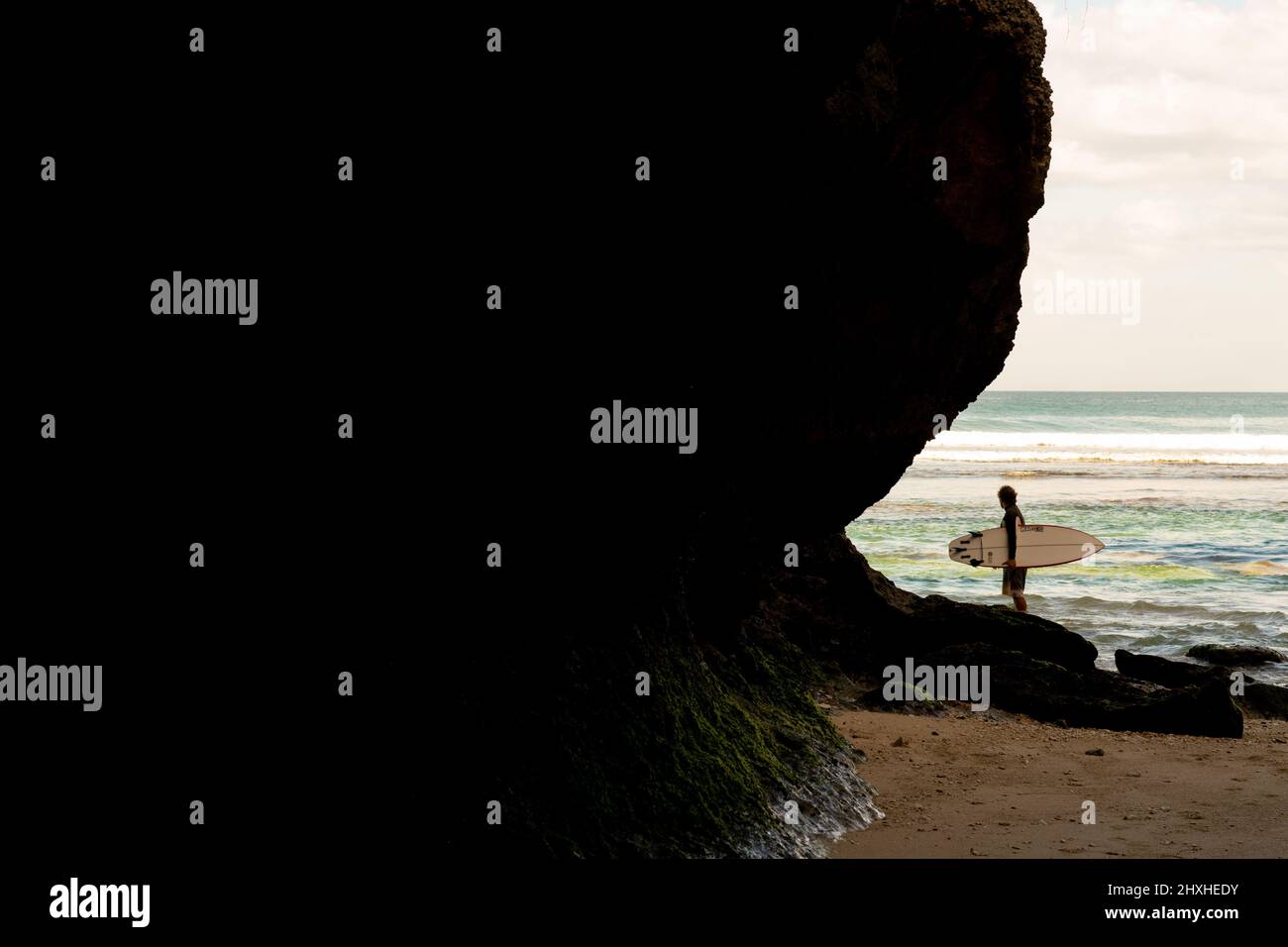 A man walking on the beach with a surfboard Stock Photo - Alamy