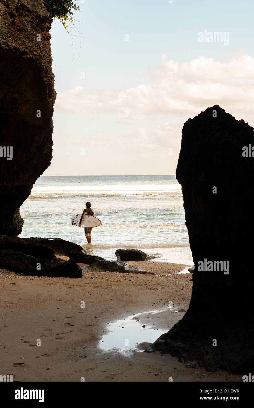 A man walking on the beach with a surfboard Stock Photo - Alamy