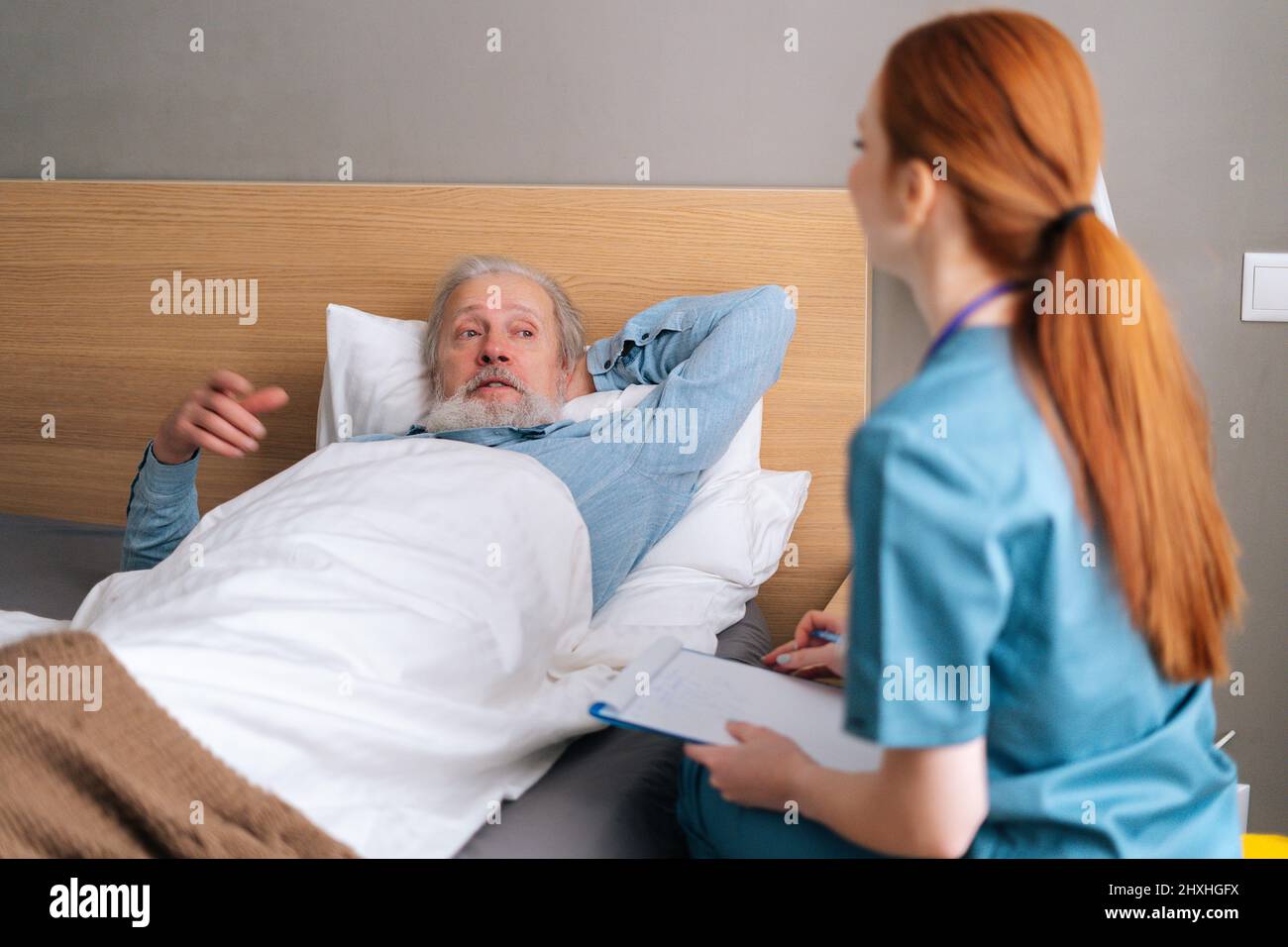 Side view of female caregiver writing down diagnosis and symptoms in