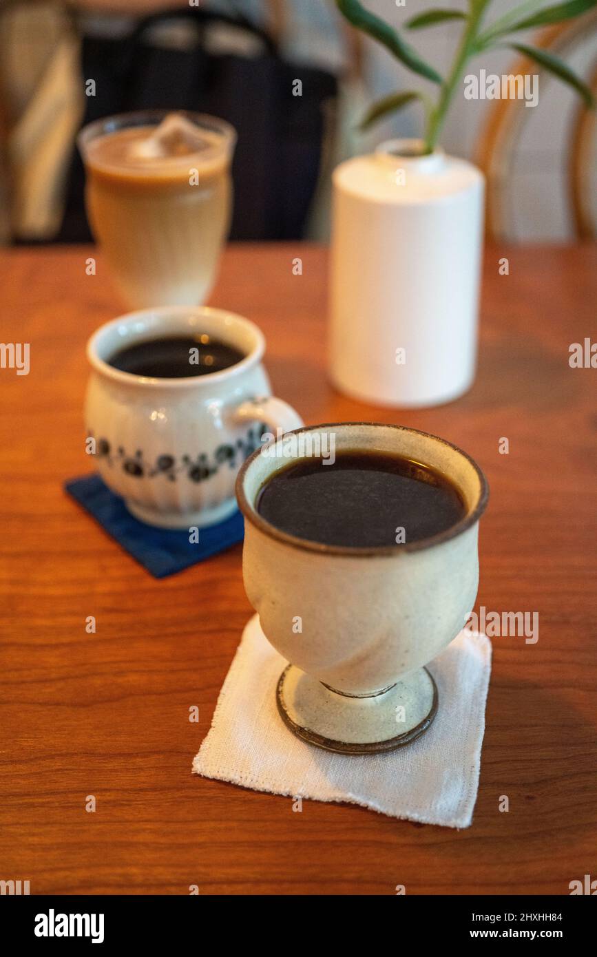 Coffee break, cup of coffee with mikl tea in the background. Stock Photo