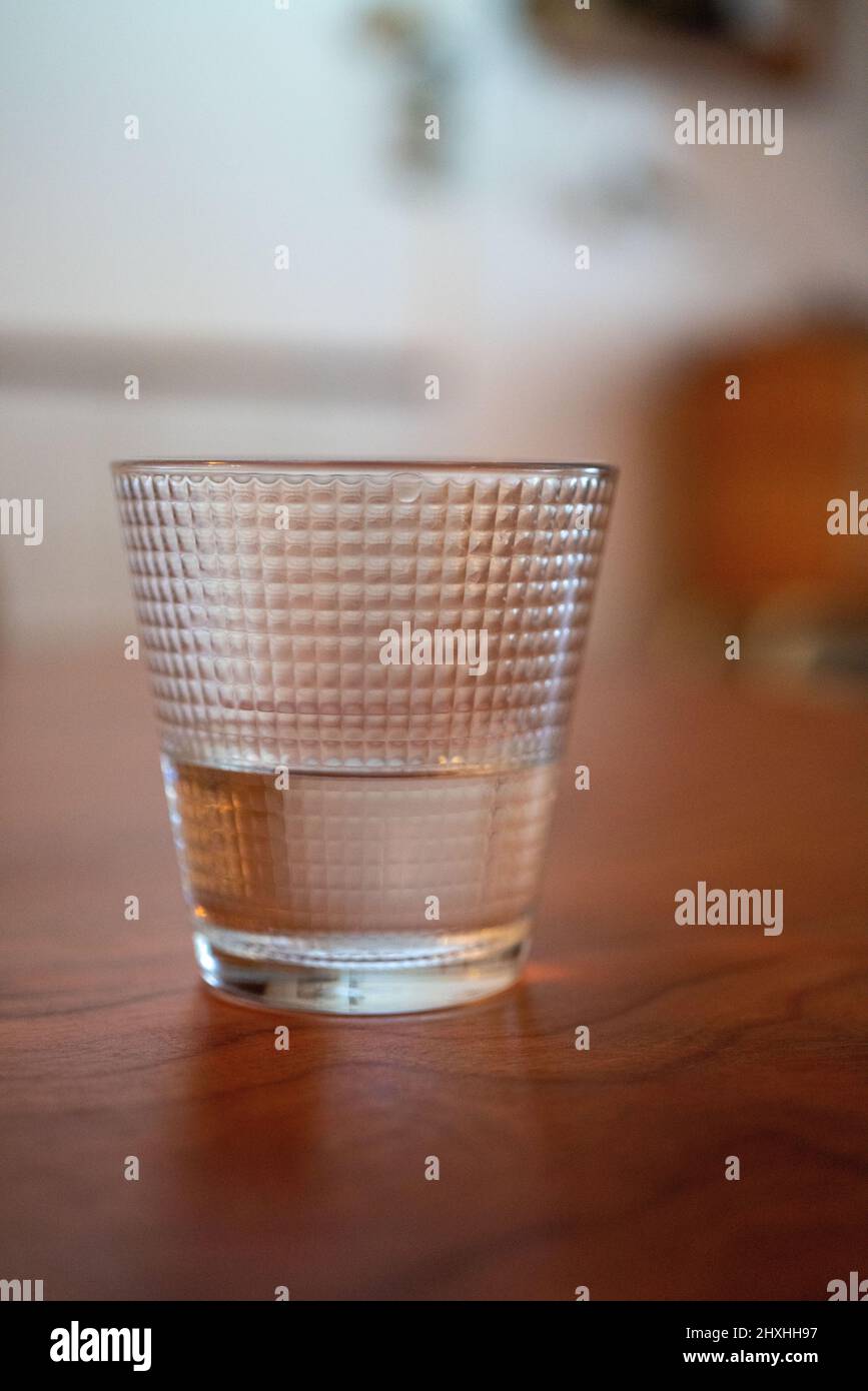 Cup of water isolated on brown. Cup of water on the table. Stock Photo