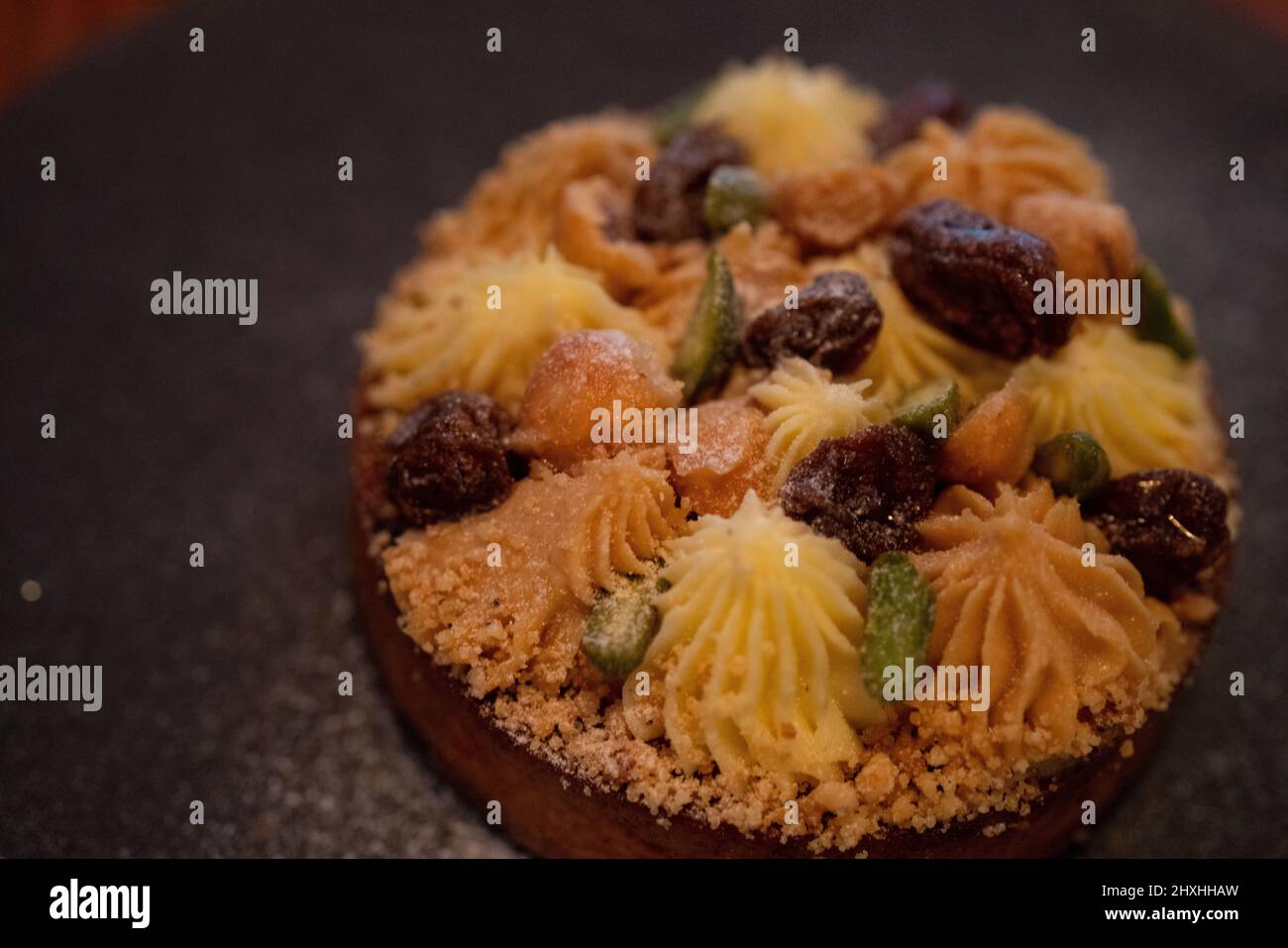Small tart on the palte, with cream, nuts and raisins  on it. Stock Photo