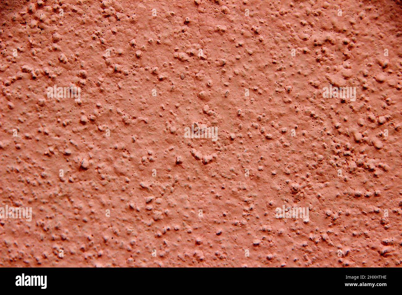 Close-up of pink painted concrete wall showing coarse sandy grains Stock Photo