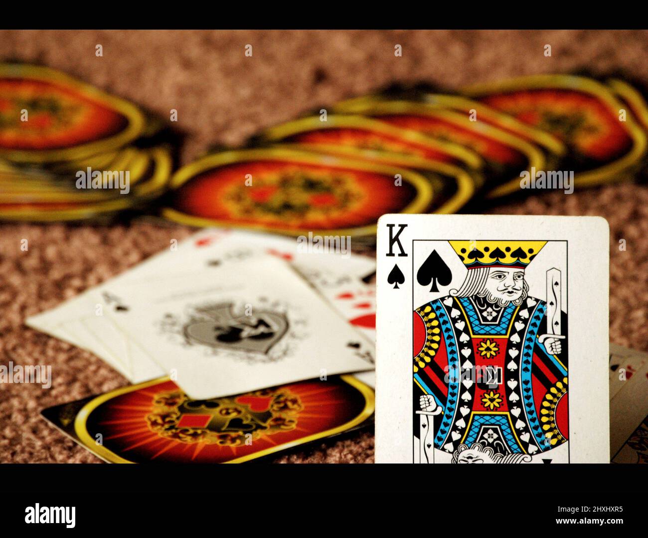 King Spade card kept standing with other playing cards at the