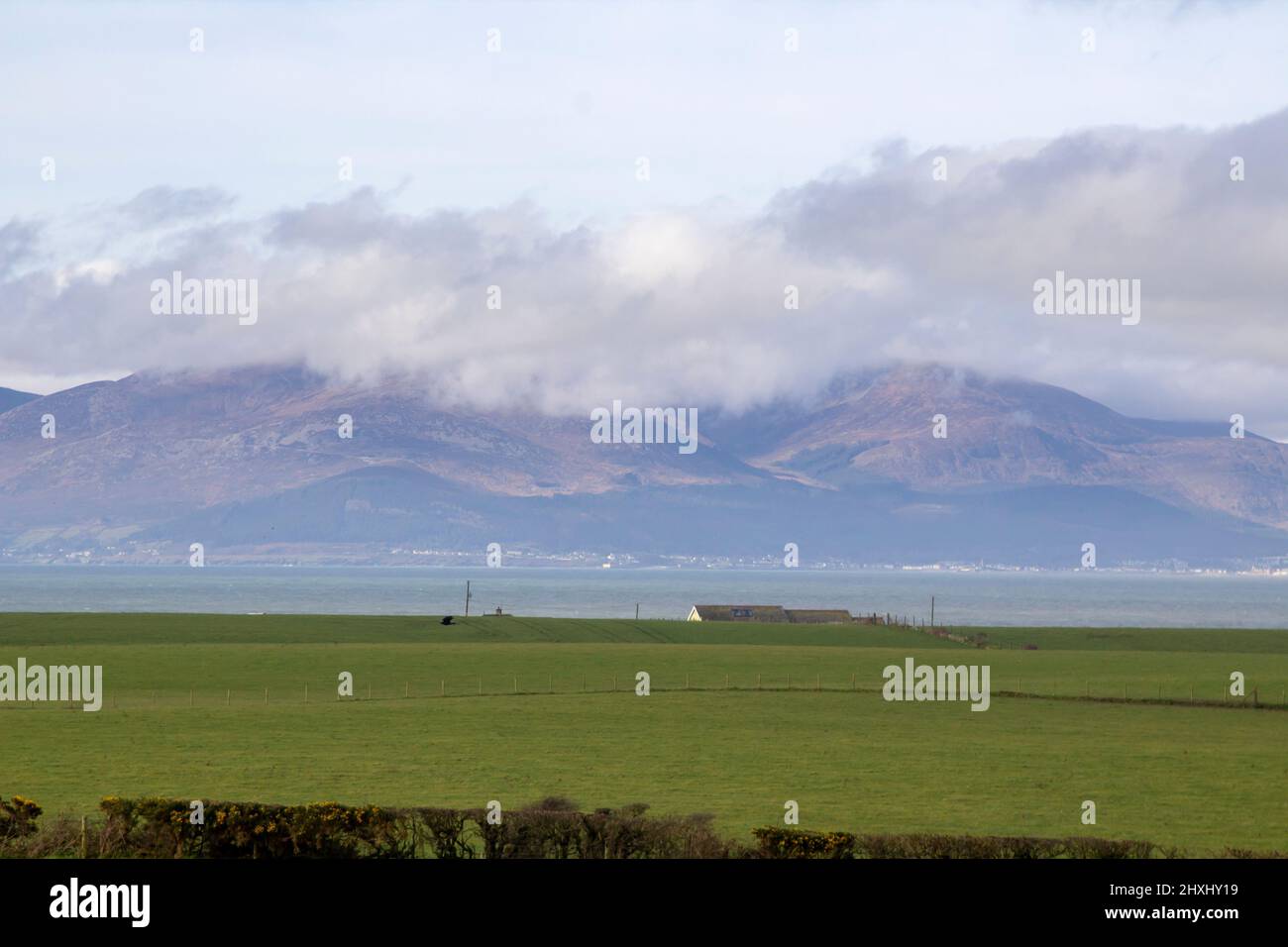 10 March 2022 A view of the Mourne Mountains with their cloud covered peaks. Viewed across Dundrm Bay from the Killough area in County Down Northern I Stock Photo