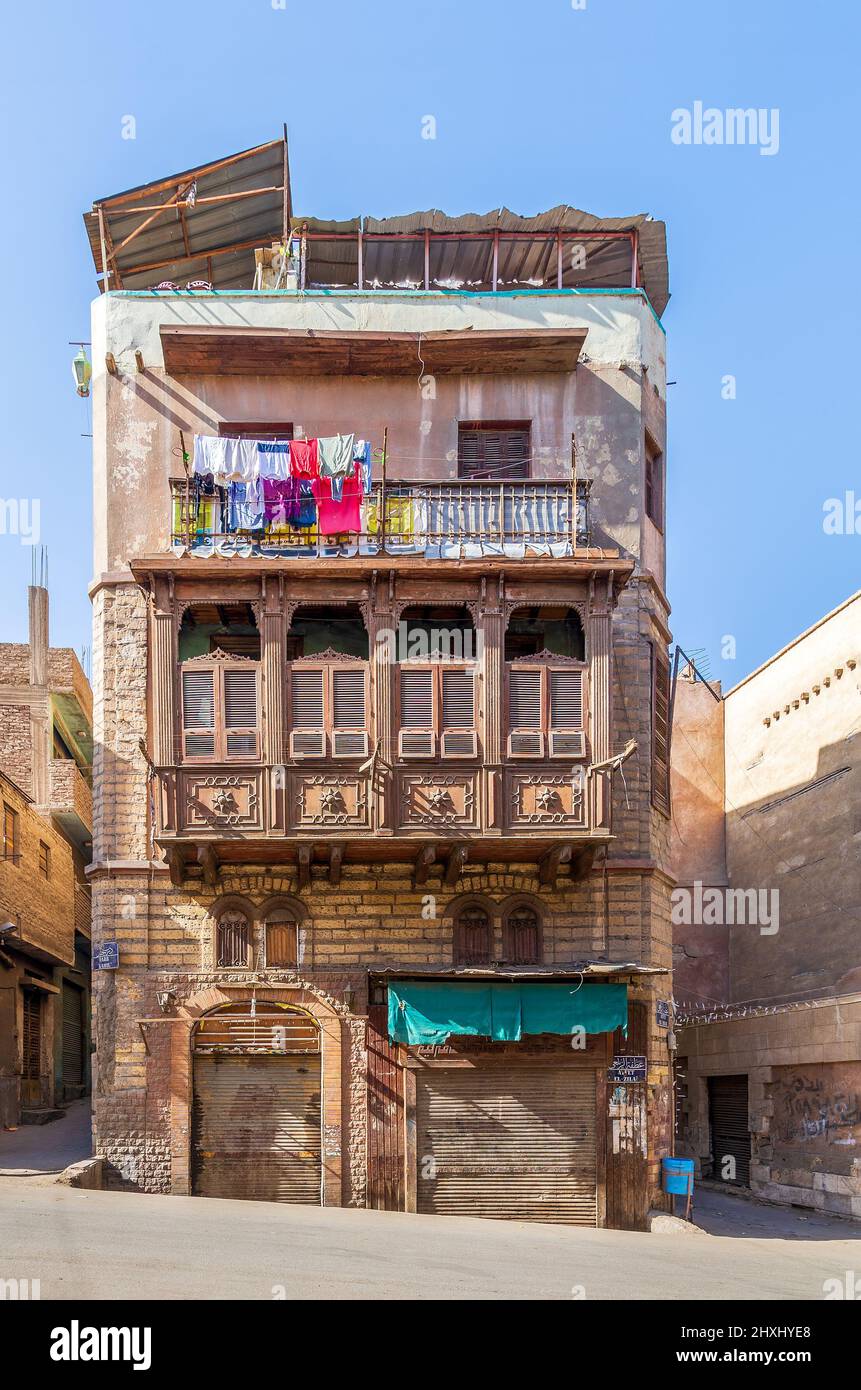 Mamluk era style oriel window with interleaved wooden grid - Mashrabiya, on shabby external wall, at 1890 historic residential building known as Sokkar House, Bab Al Wazir district, old Cairo, Egypt Stock Photo