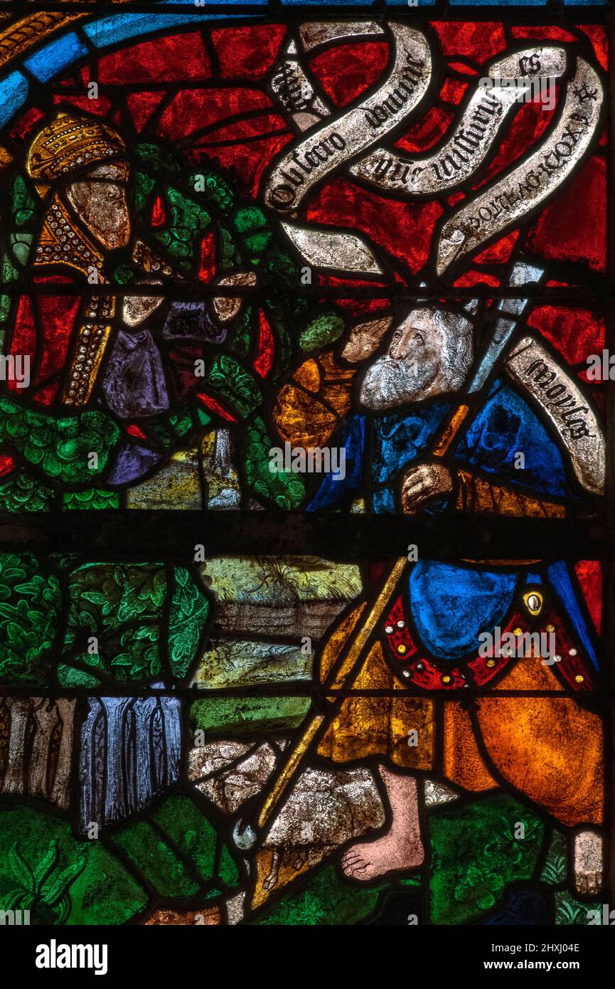 The patriarch Moses barefoot on holy ground as God, appearing in the Burning Bush, instructs him to lead the Israelites out of Egypt and into Canaan, the land of 'milk and honey': panel of Tree of Jesse window, by the stained glass masters of Troyes, installed in 1512 in the Église Saint-Rémi, the parish church at Ceffonds, Haute-Marne, Grand Est, France. Stock Photo