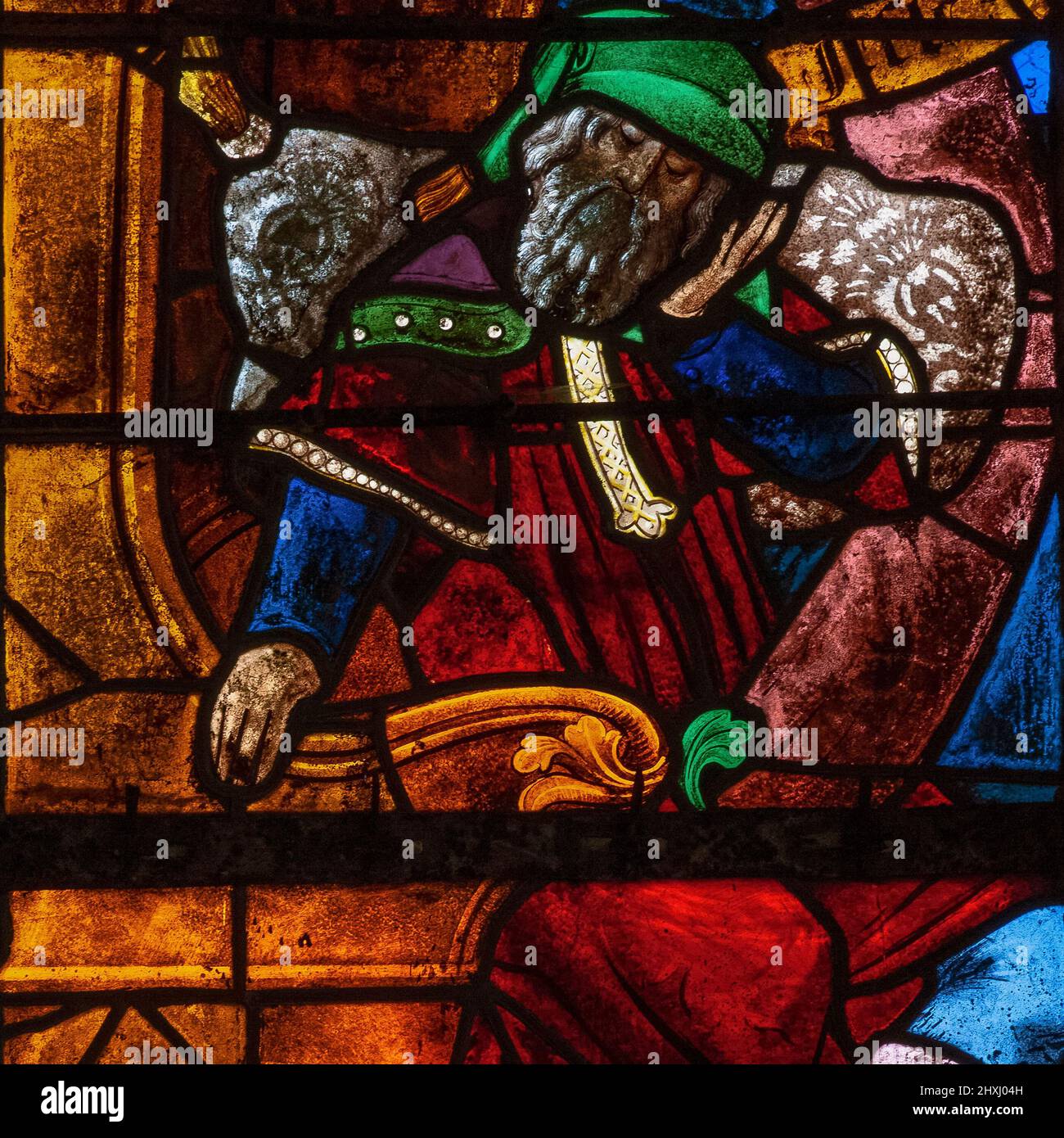 Jesse, father of King David of Israel and Judah, wears 16th century Renaissance dress as he sleeps on a carved throne with a tree trunk growing out of his body: square detail of Tree of Jesse window, by the stained glass masters of Troyes, installed in 1512 in the Église Saint-Rémi, the parish church at Ceffonds, Haute-Marne, Grand Est, France. Stock Photo