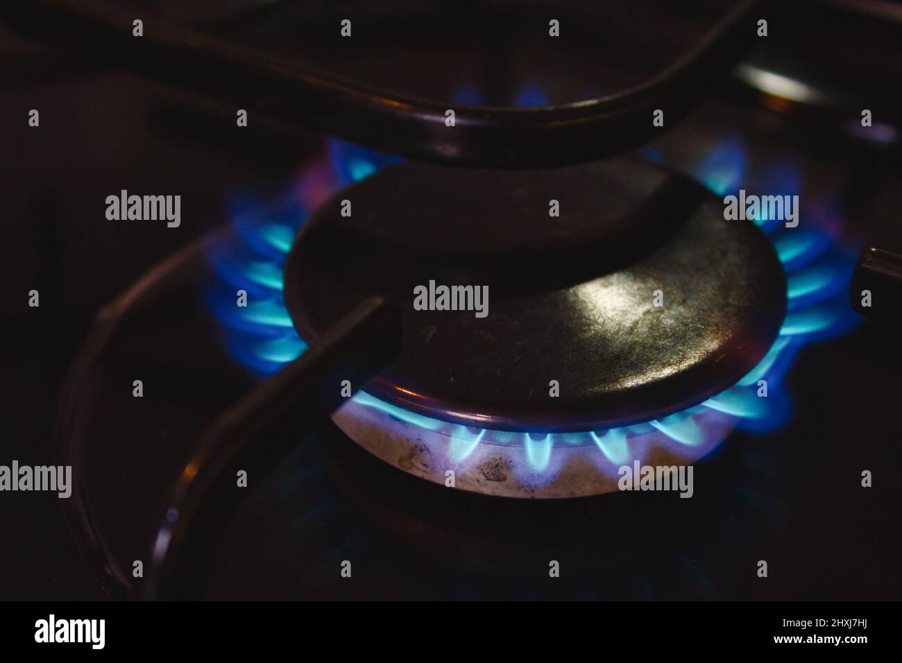 A blue gas flame hob lit up on a domestic kitchen cooker Stock Photo