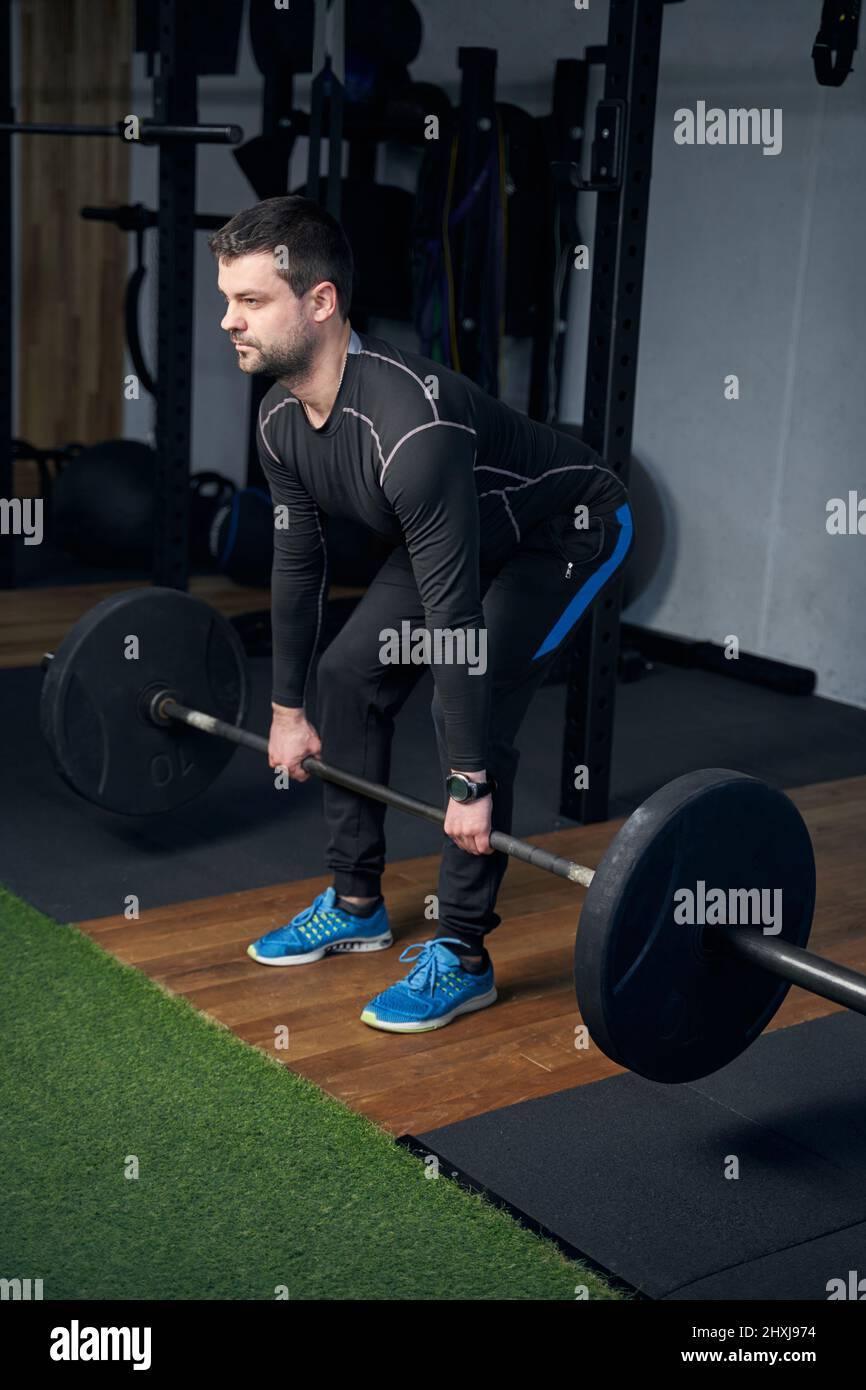 Ding Exercise Man lifting barbell during weight workout in gym Stock Photo - Alamy