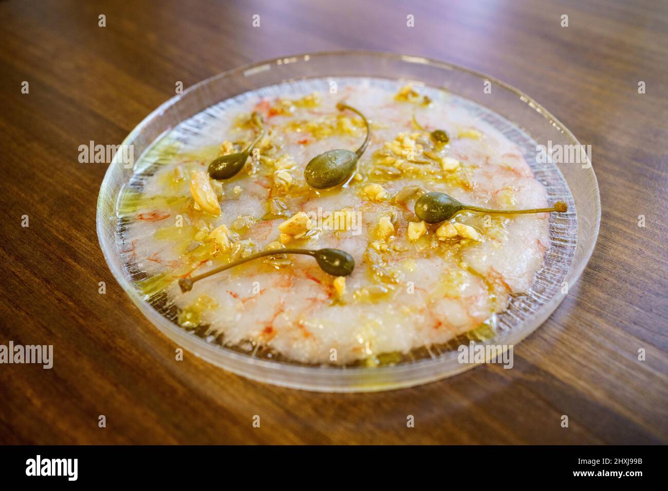 Exquisite dish with prawn carpaccio garnished with capers and nut sauce Stock Photo