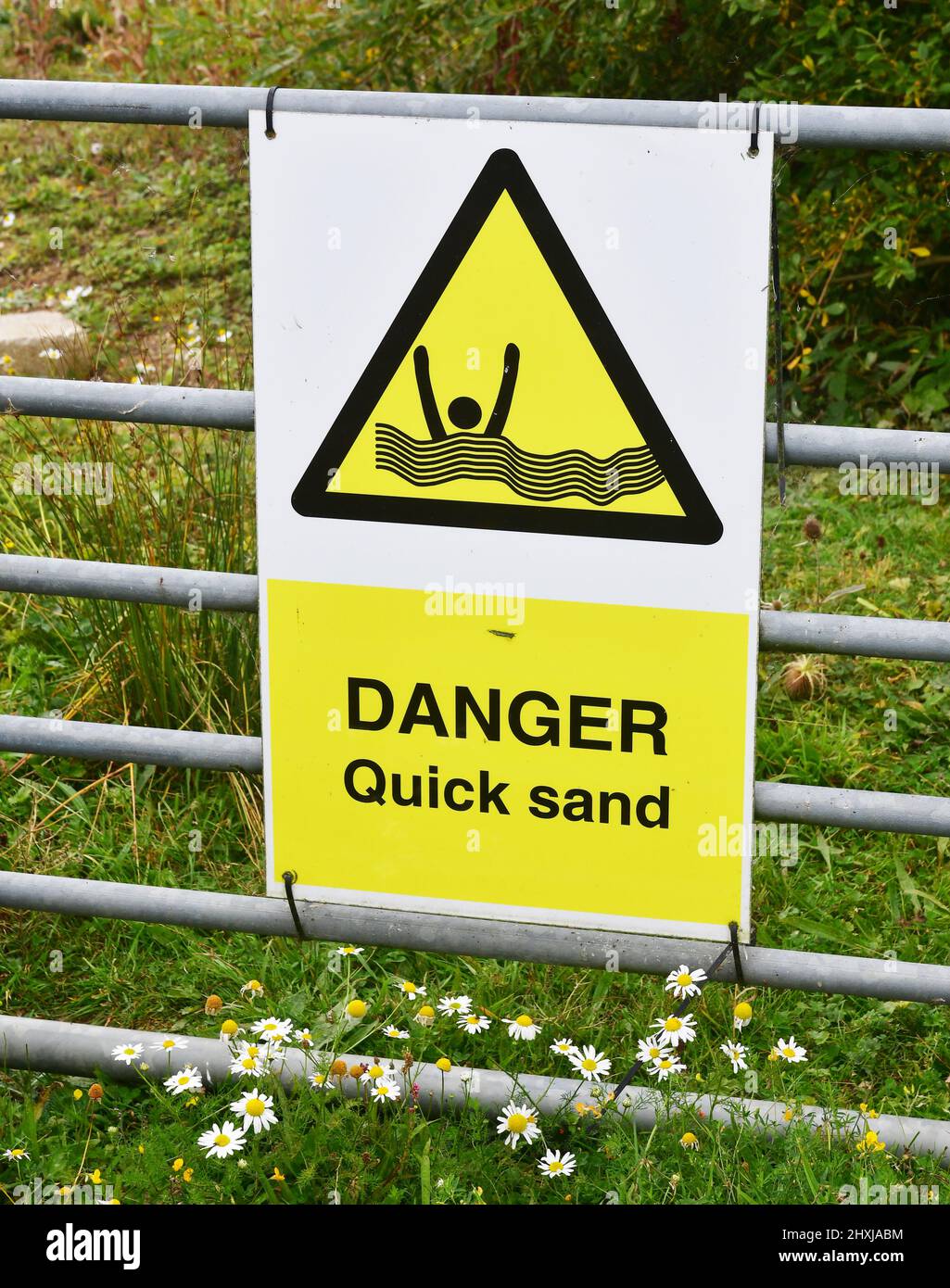 Danger Quick Sand sign on a gate at a lake in the Cotswolds, near Bowmoor Sailing Club Stock Photo