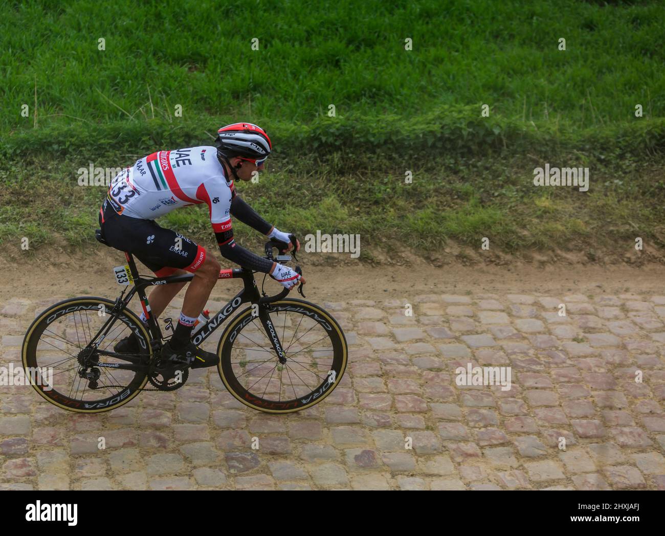 Viesly, France - April 14, 2019: The Norwegian cyclist Sven Erik Bystrom of UAE-Team Emirates Team riding in the peloton on the cobblestone road from Stock Photo