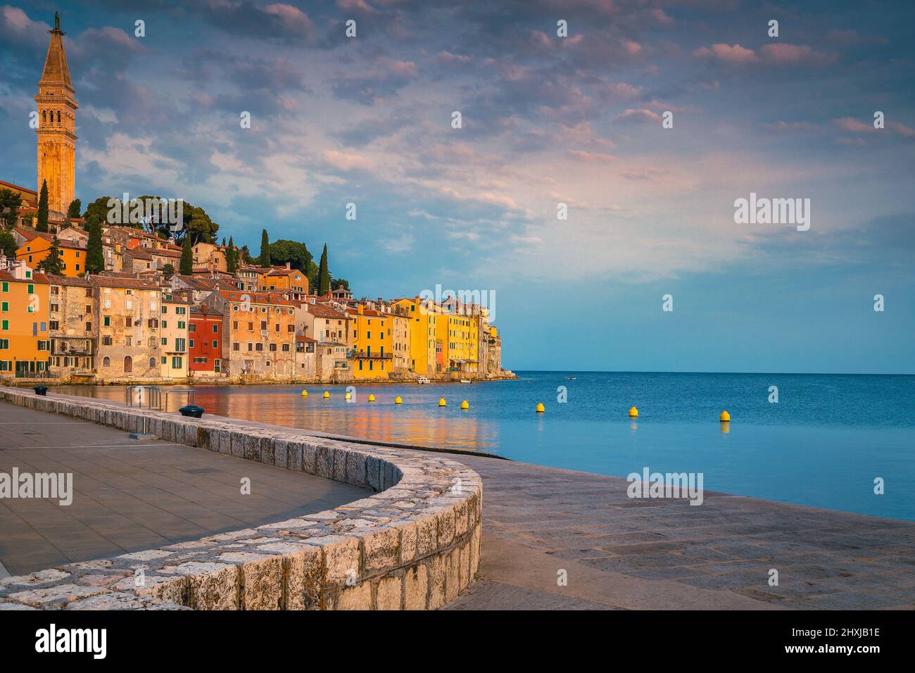 Picturesque walkway and waterfront with colorful old buildings in Rovinj at sunrise, Istria, Croatia, Europe Stock Photo