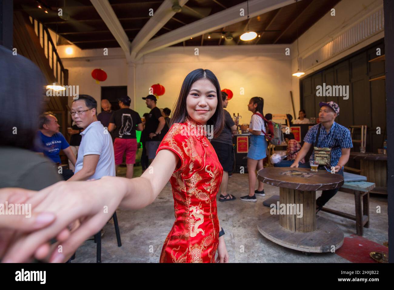 Chinese women travel with chinese new year costume leading man hand to travel in Yaowarat Bangkok Thailand Stock Photo