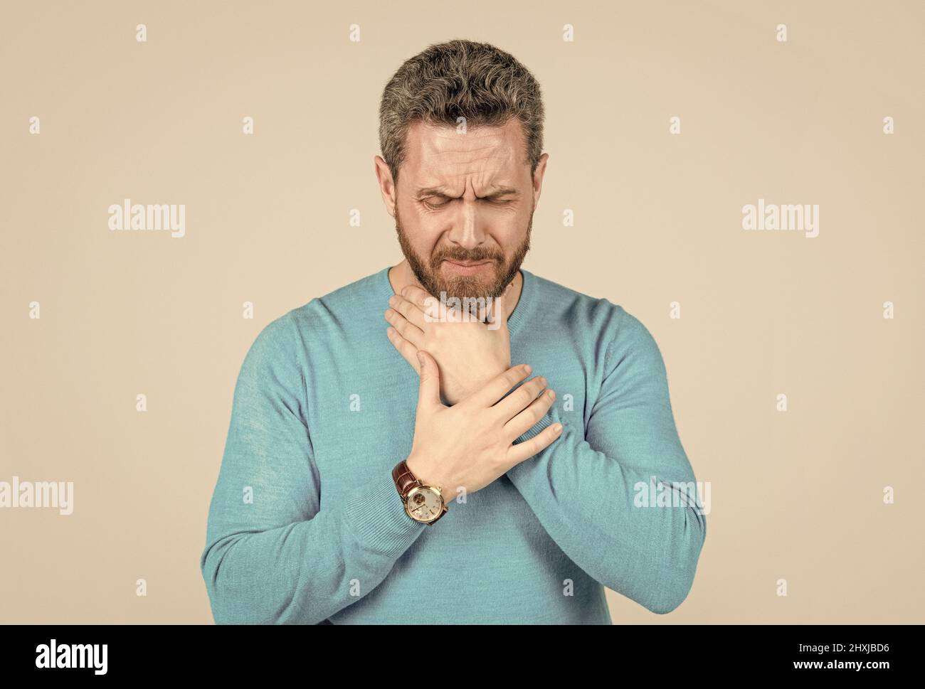 mature man with beard suffer from sore throat on grey background, cold ...