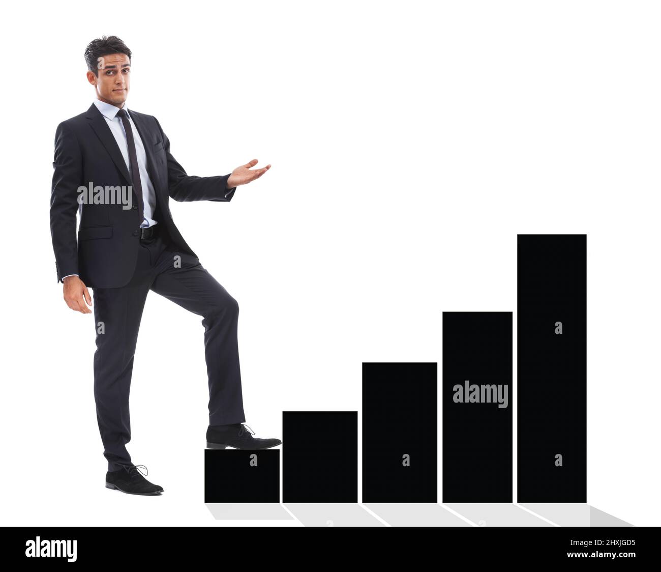 The statistics show.... A handsome young businessman standing next to a black bar-graph and using it as a step against a white background. Stock Photo